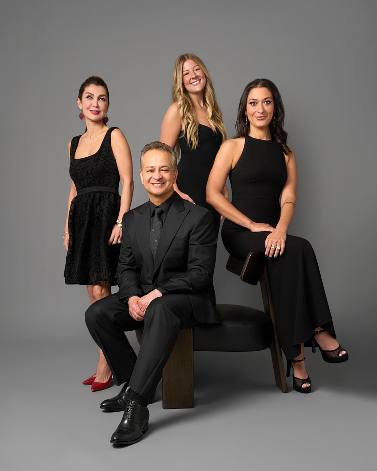 Four individuals in formal black attire.