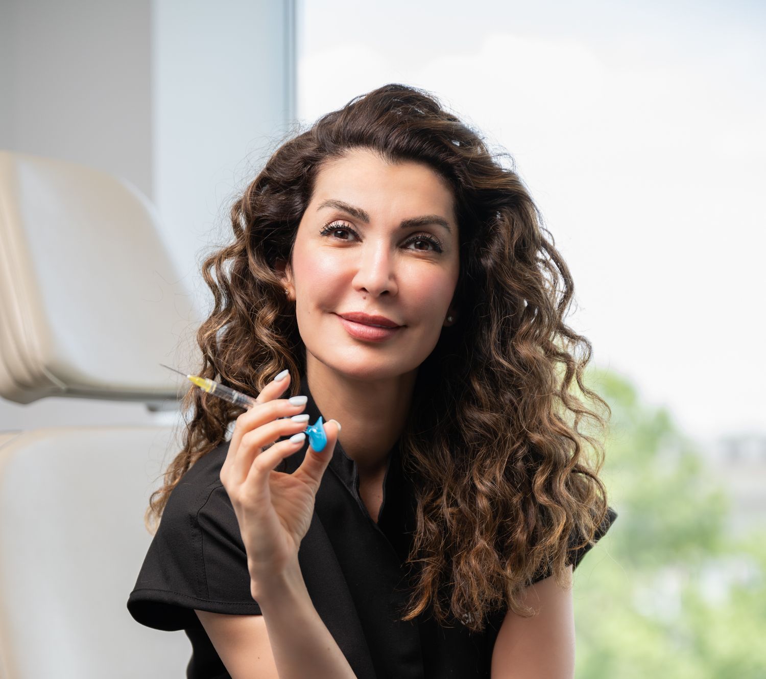 Professional woman holding syringe and blue object.