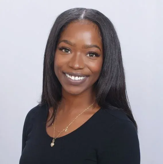 Smiling woman with long black hair in portrait.
