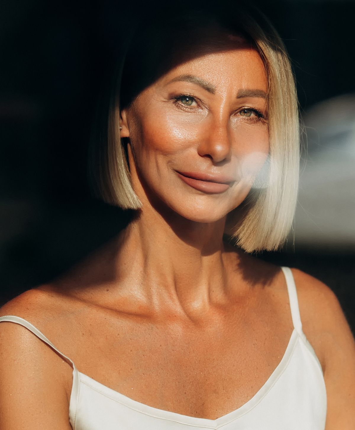 Woman with short hair in soft sunlight.