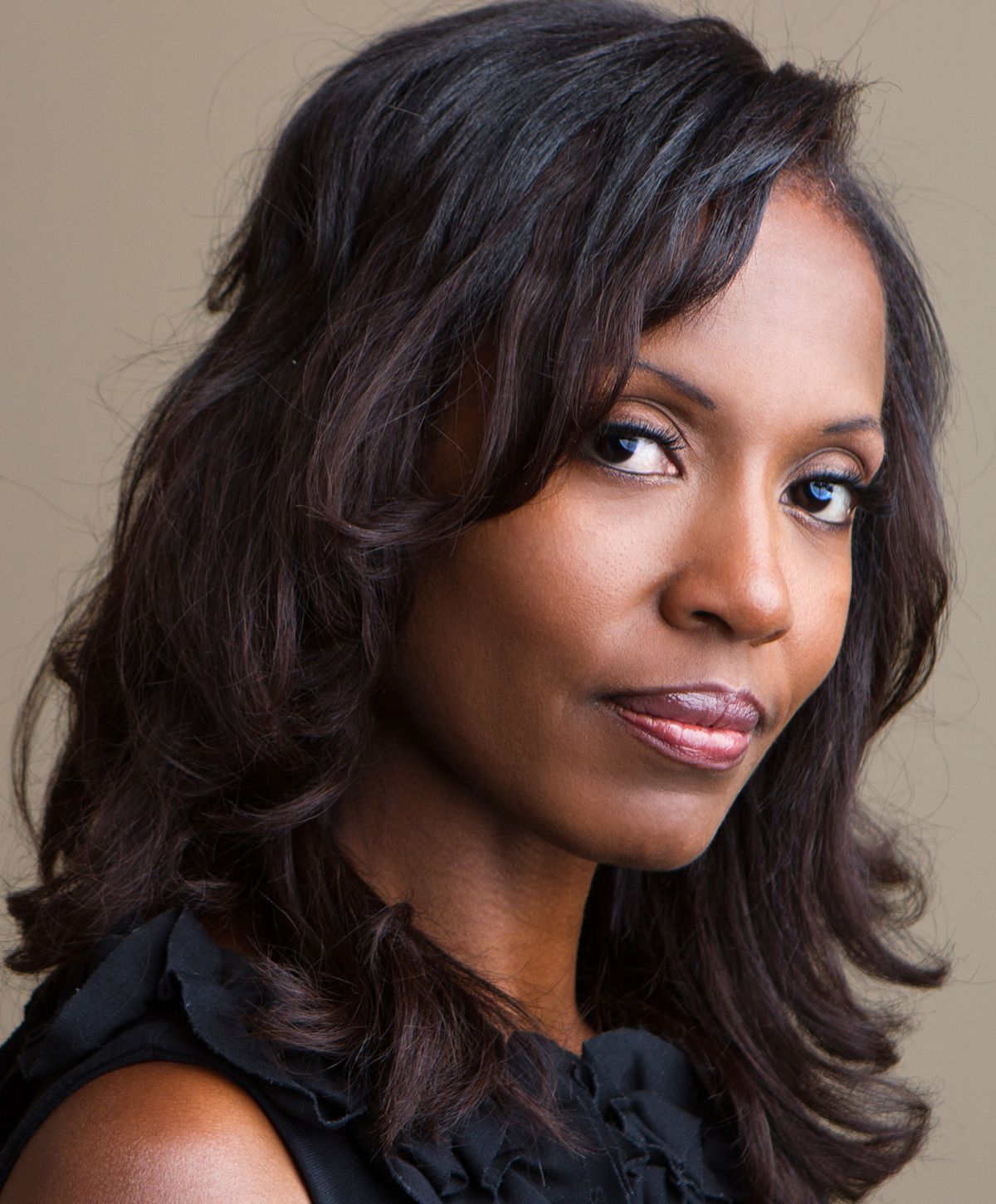 Professional portrait of a woman with wavy hair.