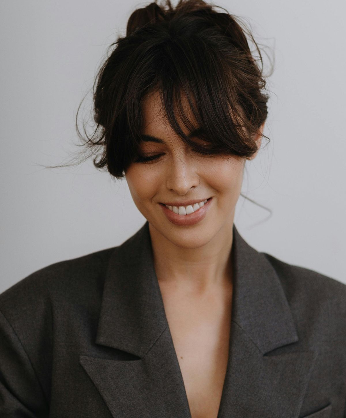 Woman with long, wavy hair and stylish outfit.