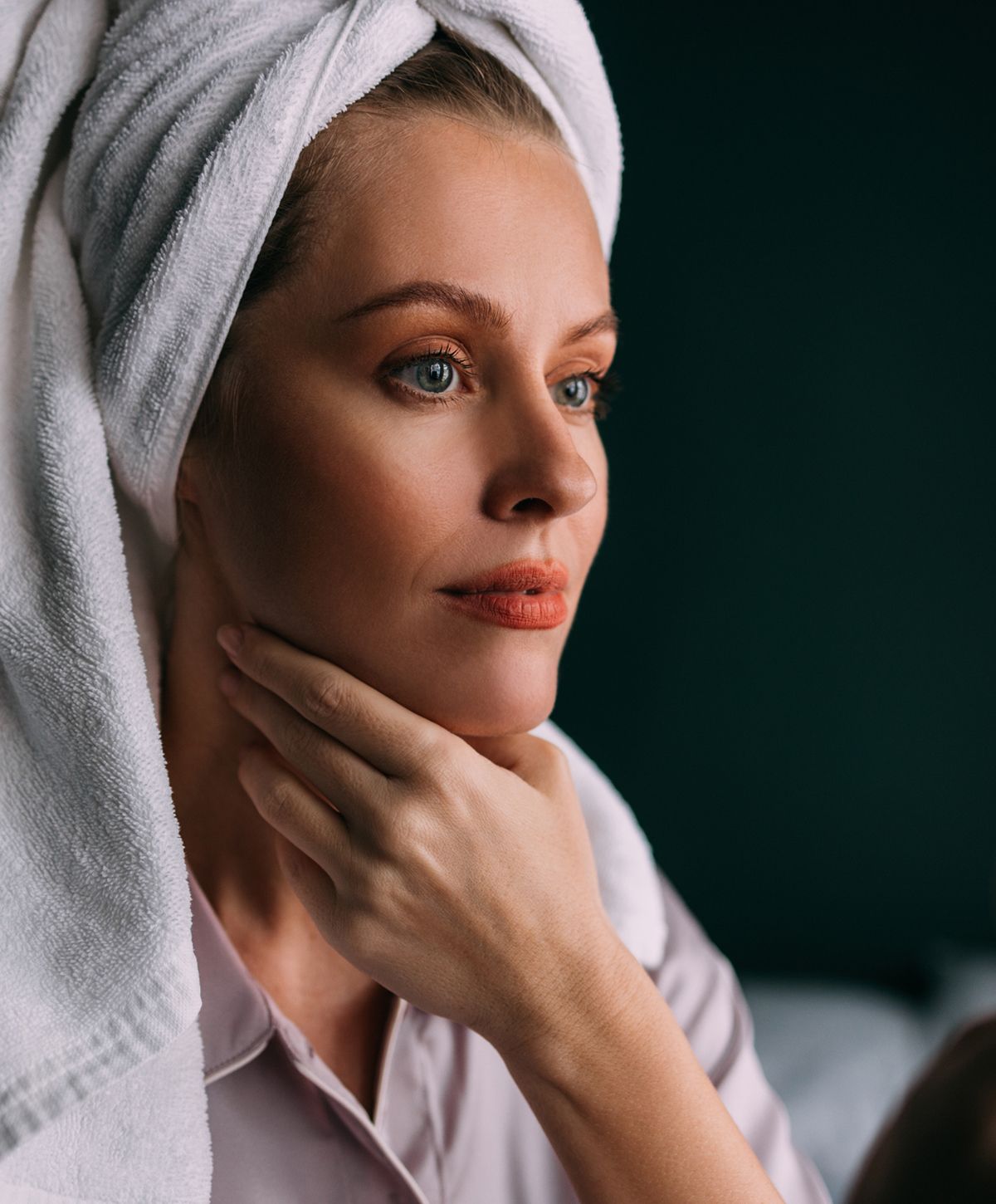 Woman in towel reflecting thoughtfully.