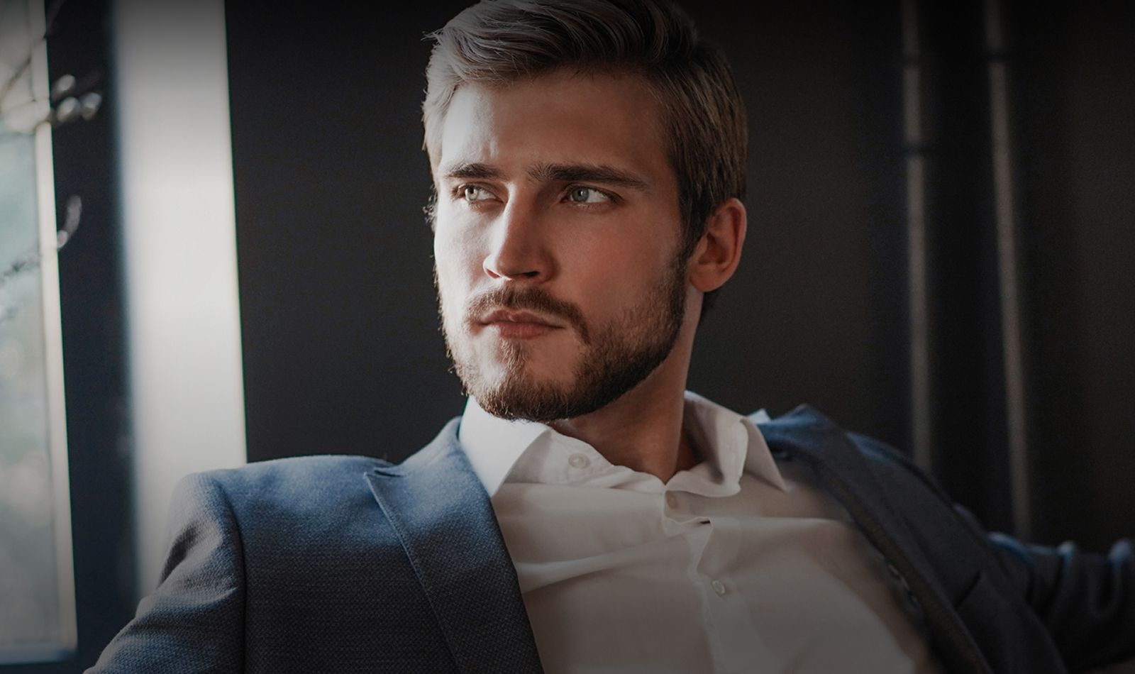 Young man in a suit, thoughtful expression.