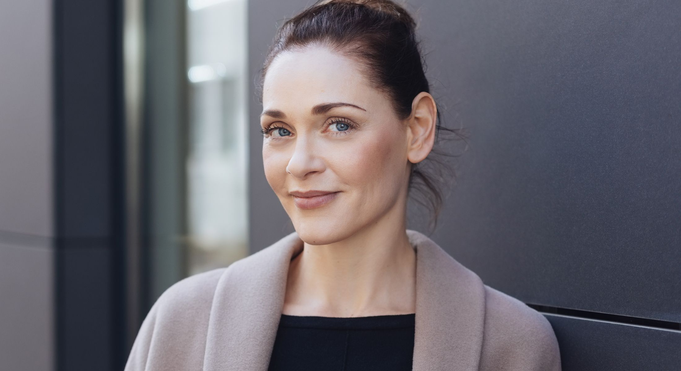Woman smiling in a modern urban environment.