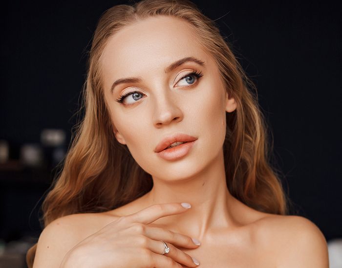 Woman with long hair posing thoughtfully indoors.