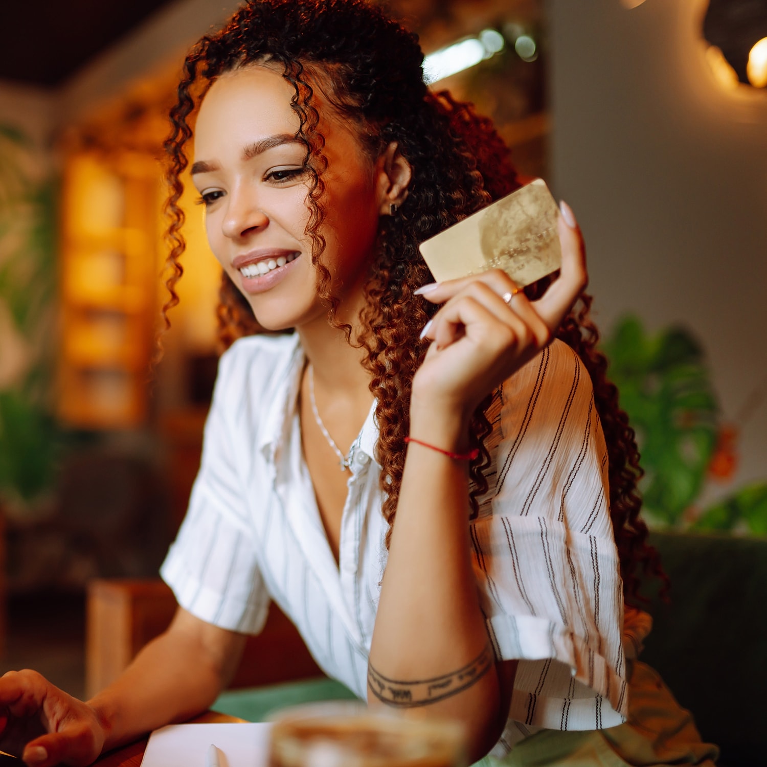 Woman smiling with a card in a café.