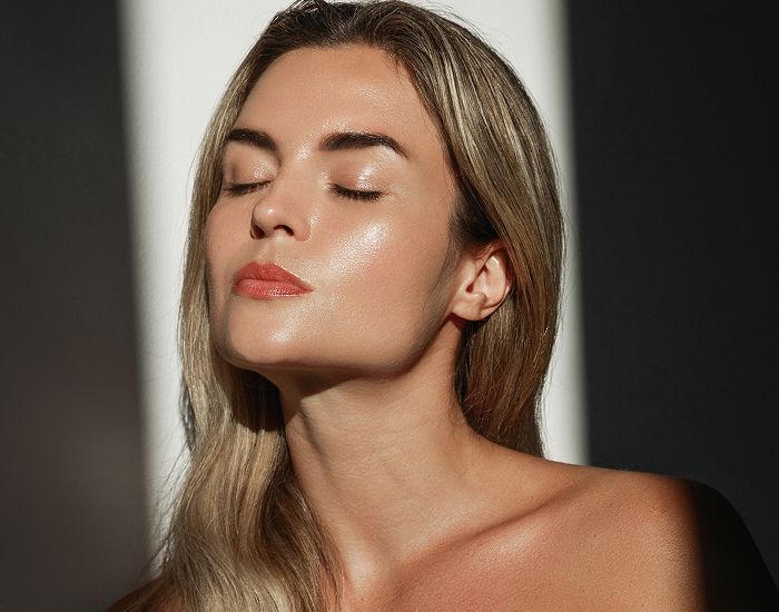 Woman with closed eyes in soft lighting.