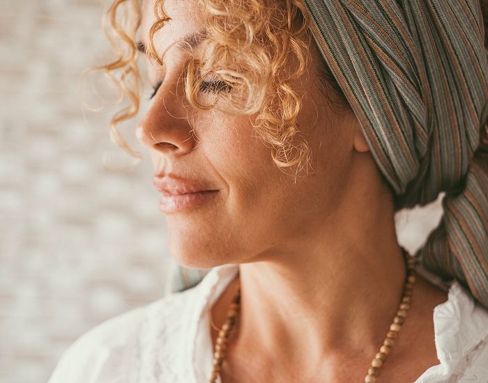 Woman with curly hair wearing a headscarf.