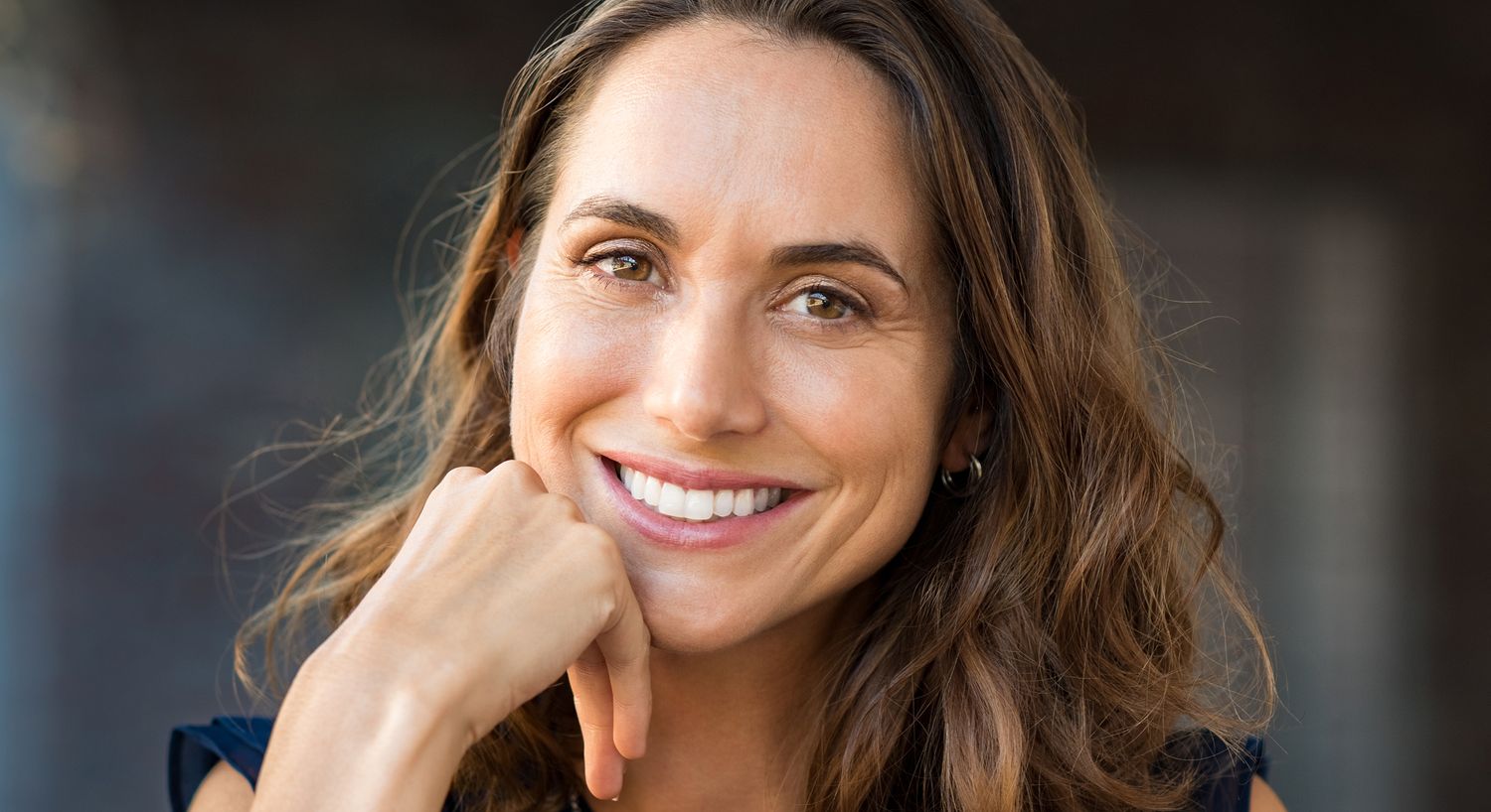 Smiling woman with long, wavy hair.