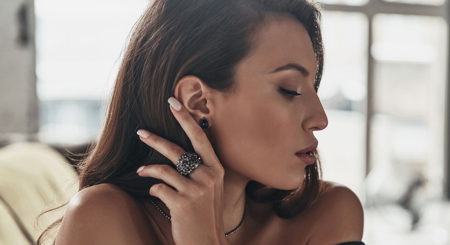 Woman wearing elegant jewelry, side profile view.