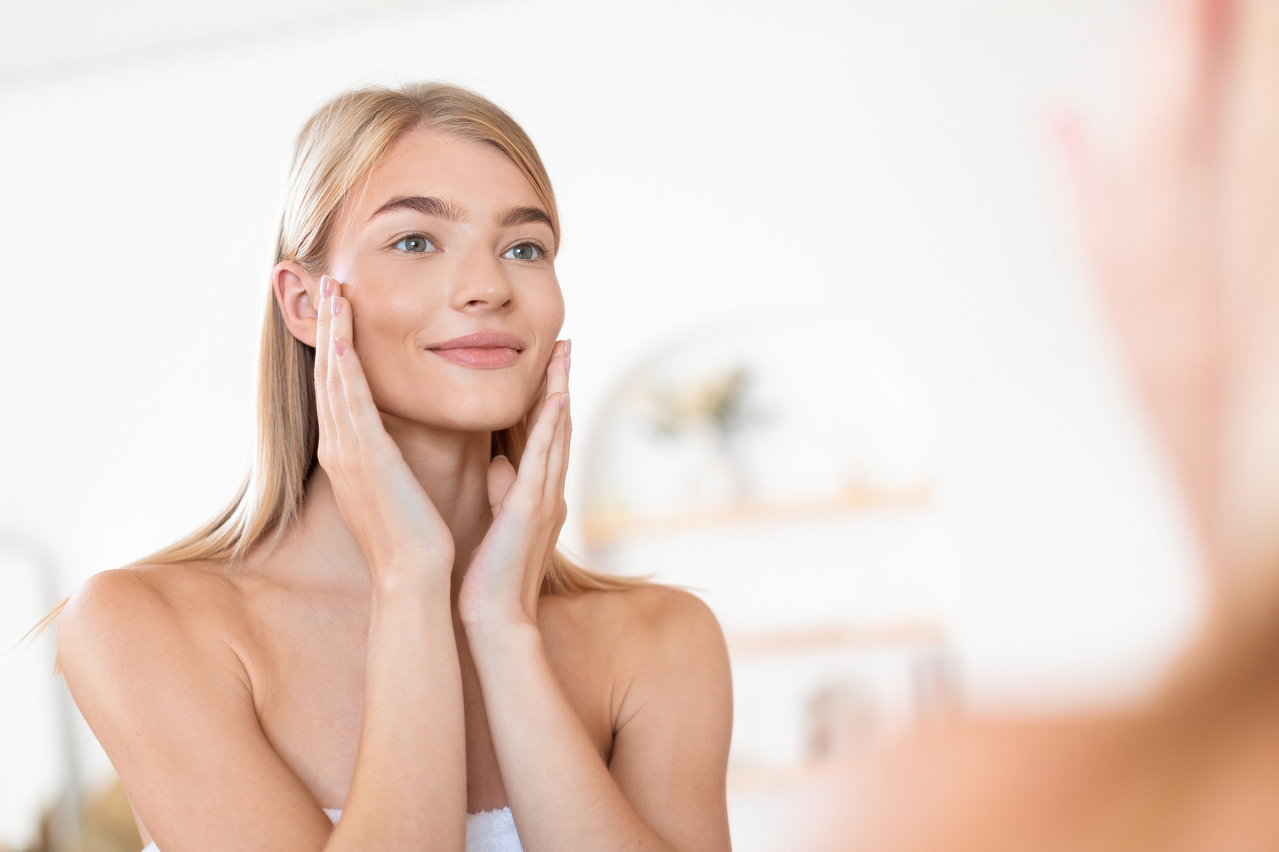 Woman with gray hair looking in mirror.