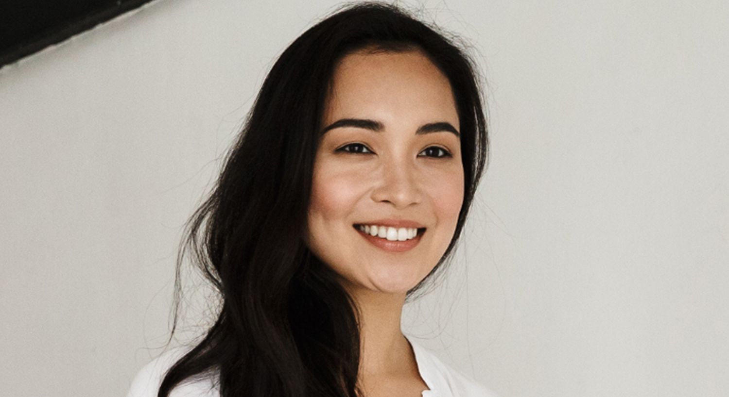 Smiling woman with long, dark hair.