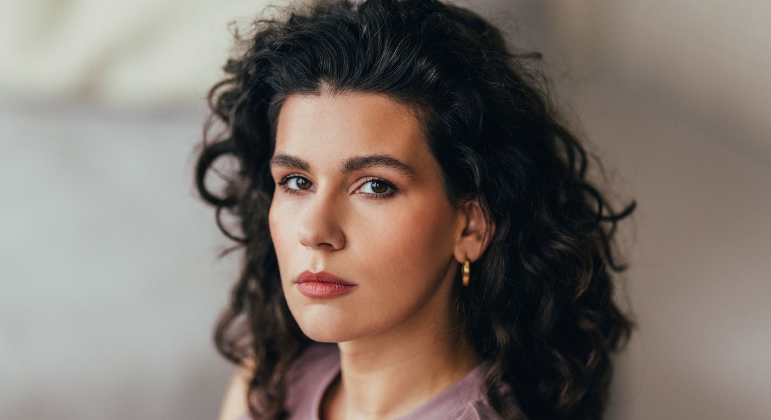 Woman gazing confidently with hand on forehead.