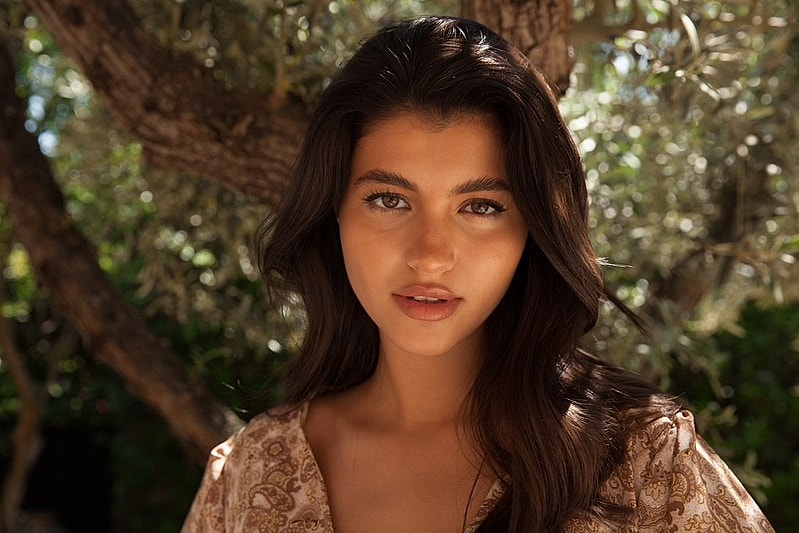 Natural light portrait of a woman with glowing skin.